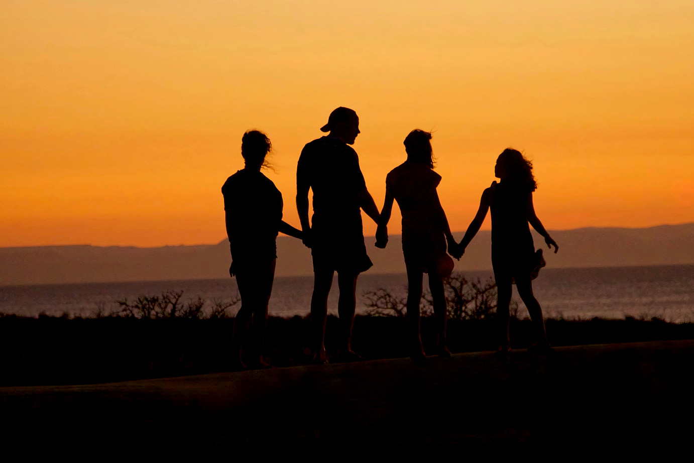 Familie mit Kindern vor Sonnenuntergang