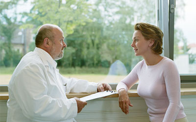 Arzt und Patient sitzen am Fenster