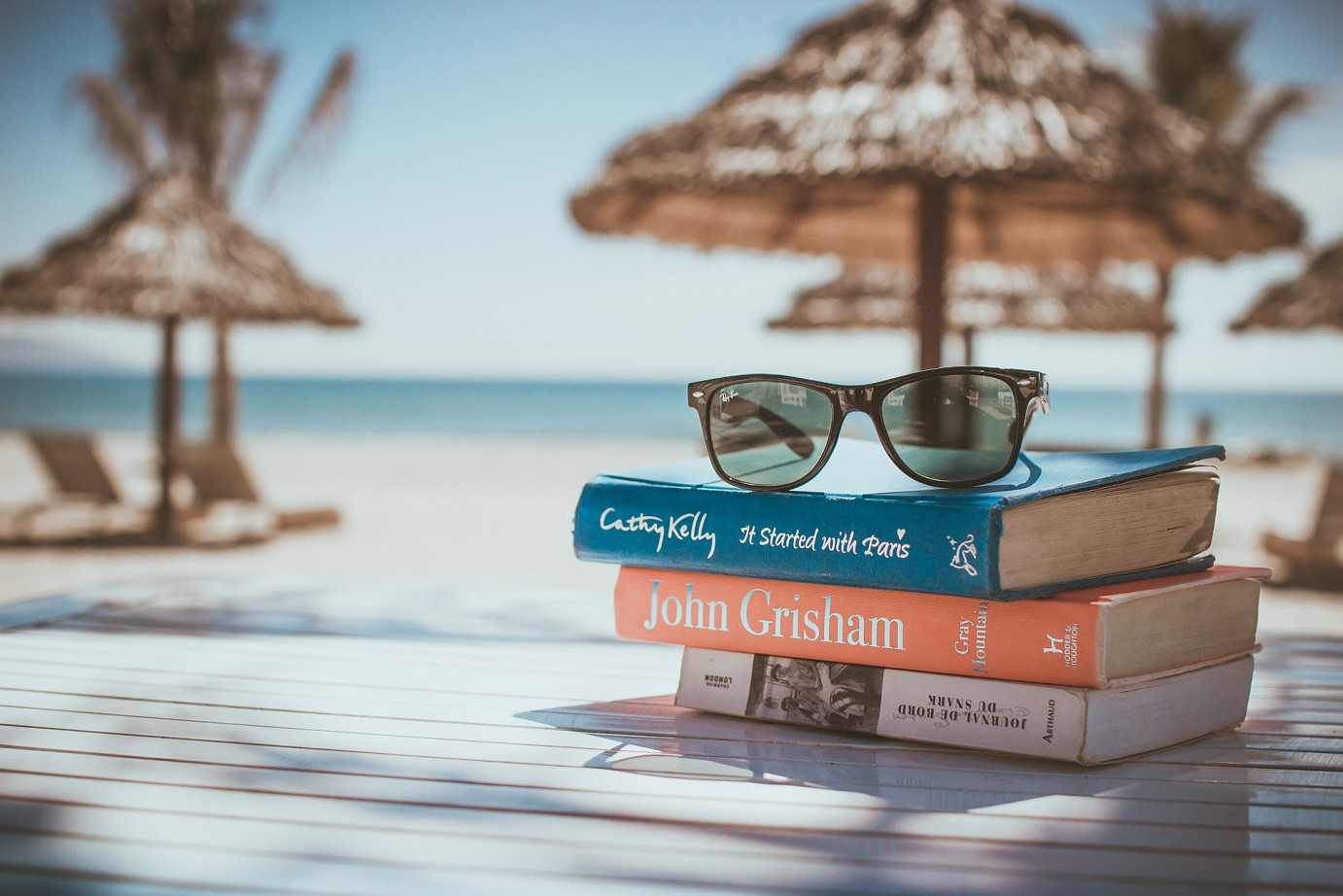 Bücher und Sonnenbrille am Strand