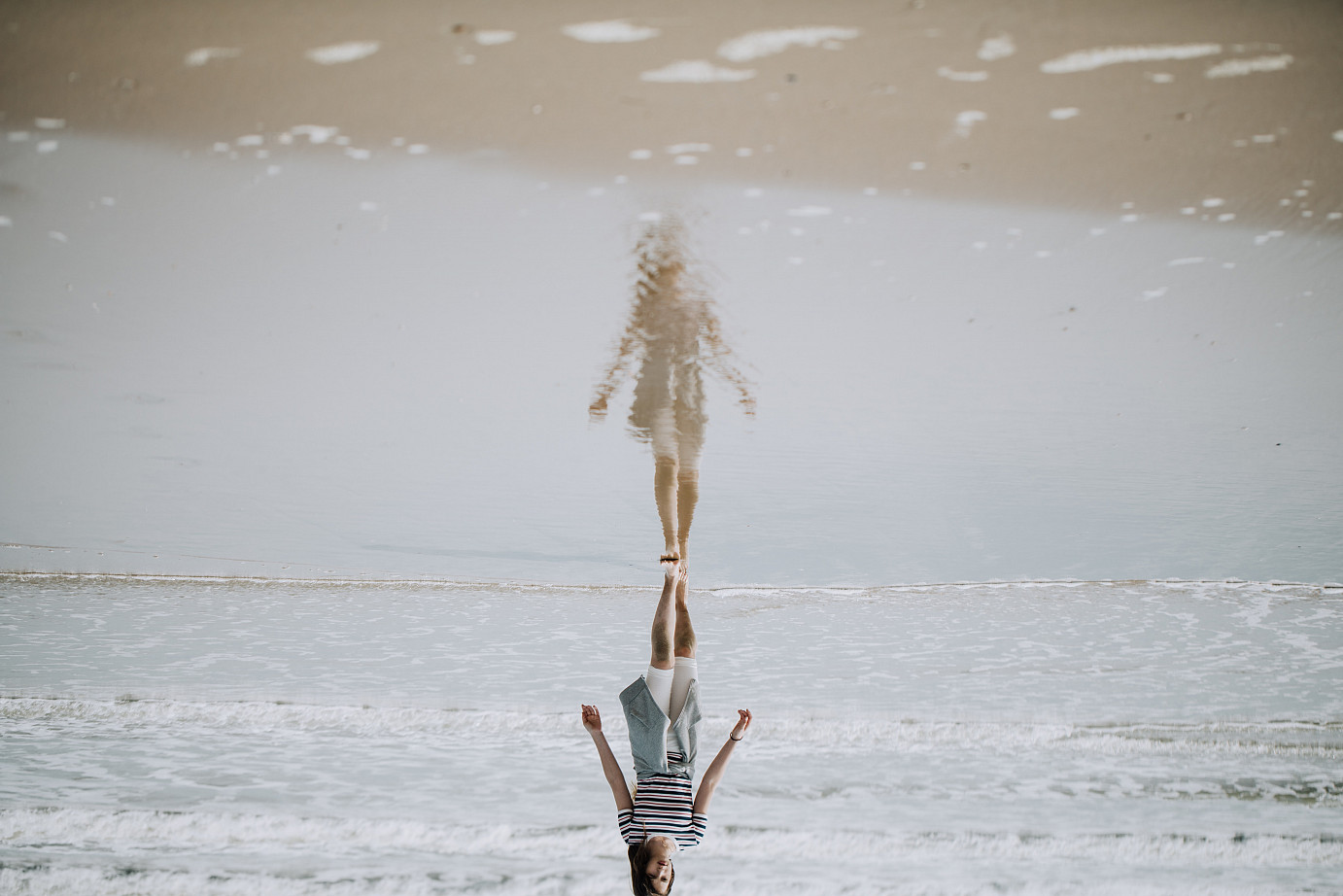 Eine Frau, die am Strand entlang im Wasser geht