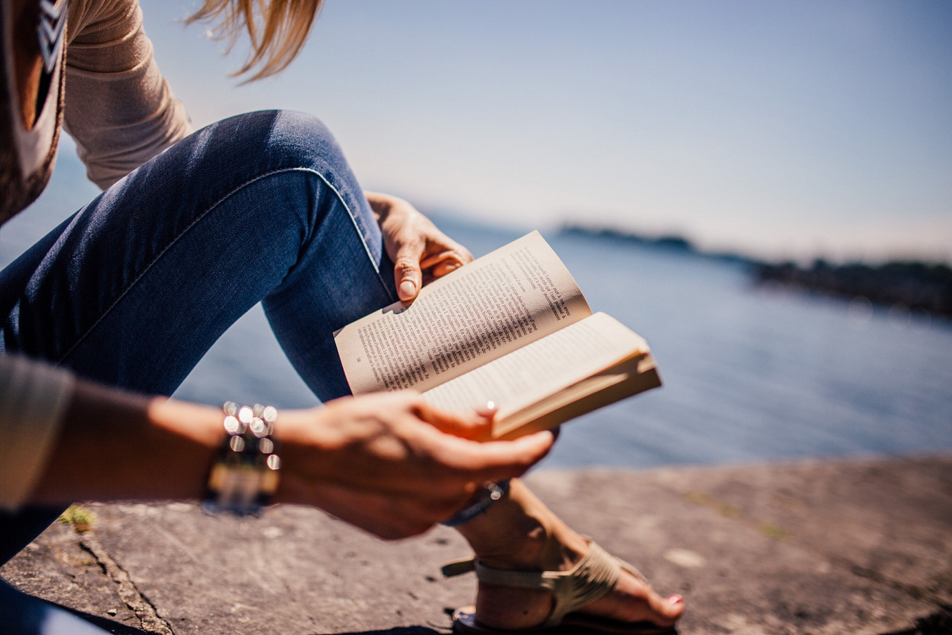 Frau liest ein Buch in der Sonne