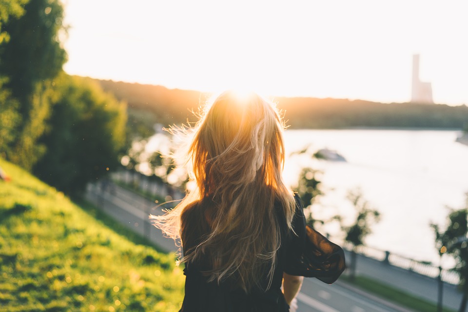 Junge Frau schaut in die Sonne.